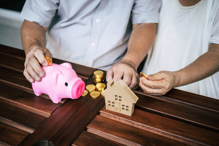 Elderly Couples talking about finance with piggy bank