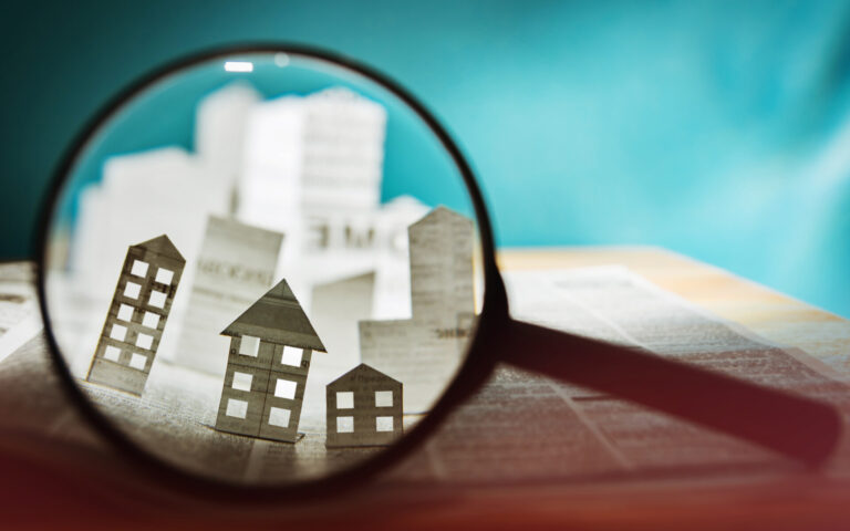 Paper house under a magnifying lens