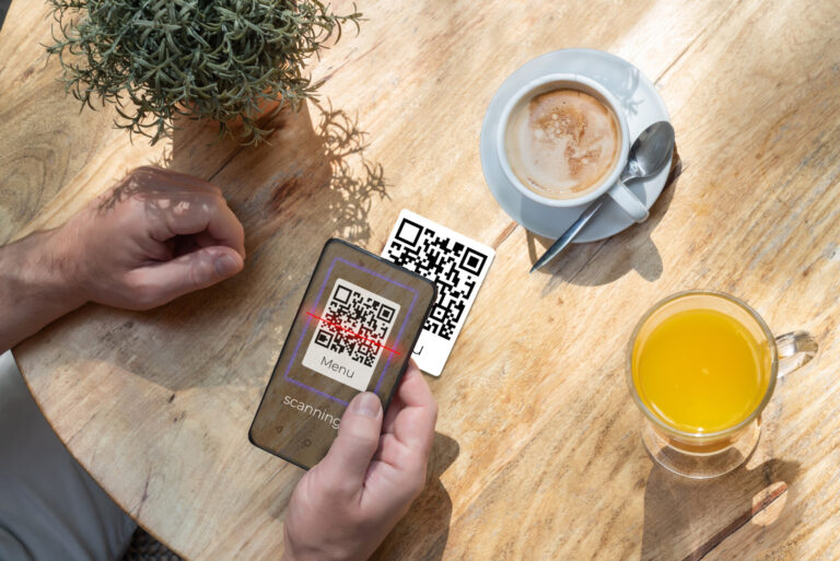A customer scanning a qr code with his cell phone in a bar or re