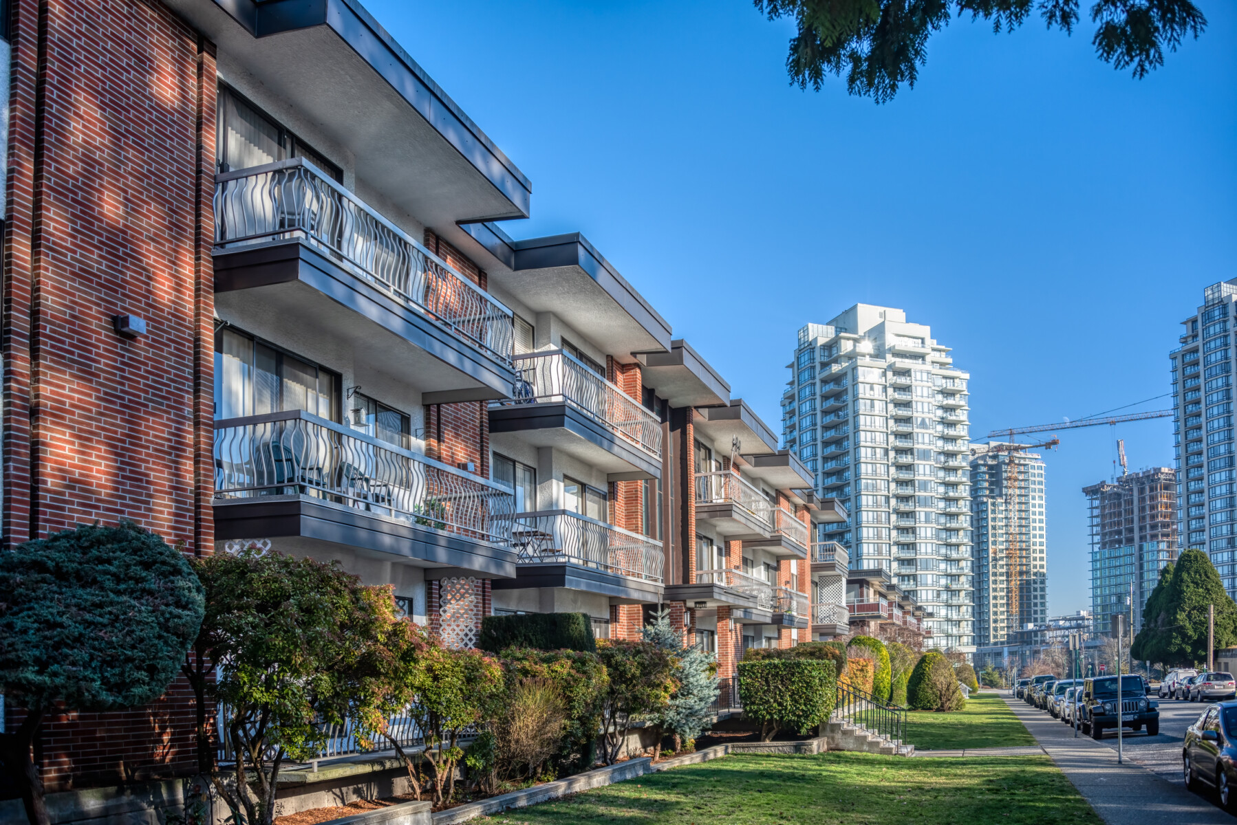 Residential apartment buildings with doorsteps from the green lawn in front.