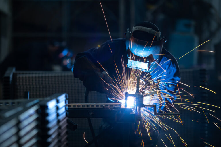Workers wearing industrial uniforms and Welded Iron Mask at Stee