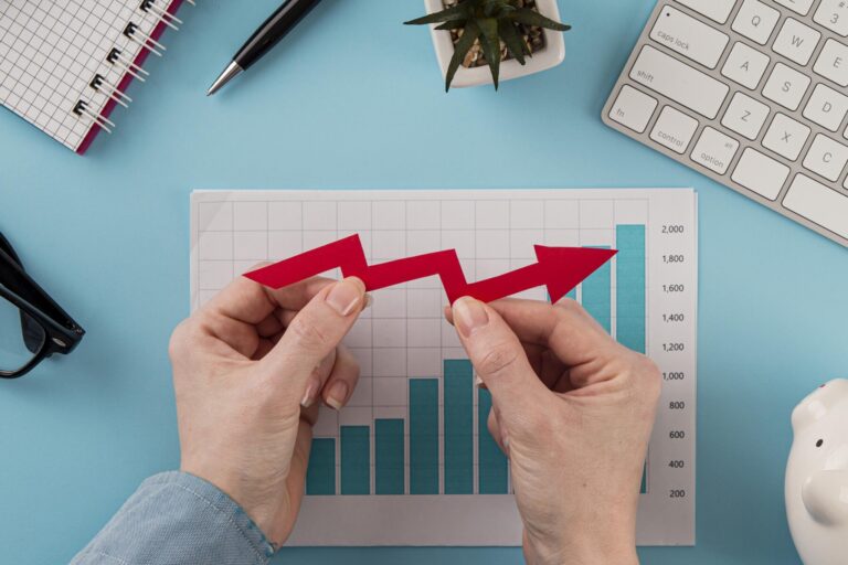 top-view-business-items-with-growth-chart-hands-holding-arrow