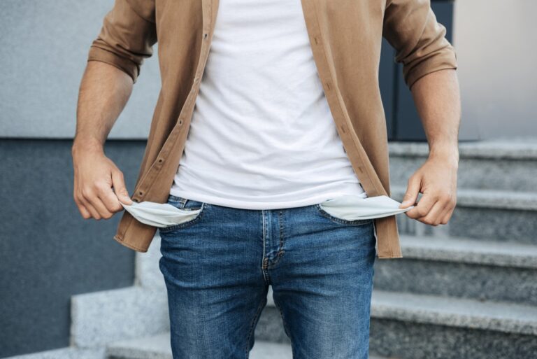 Close up hands pulling out jeans pockets