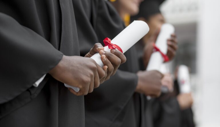 Close up graduates holding diplomas