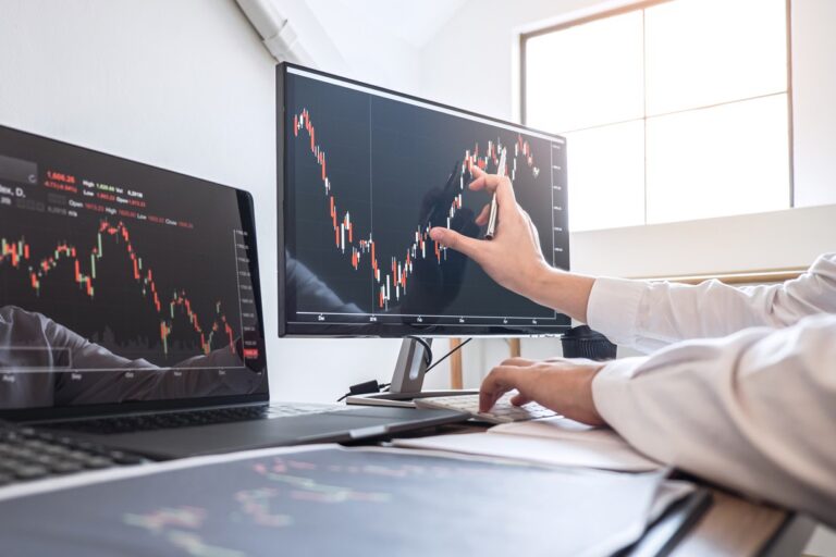 Cropped hands of businesswoman analyzing stock market data over computer in office