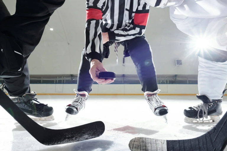 Hockey referee with puck standing ice rink two players with sticks waiting moment be first shoot it training