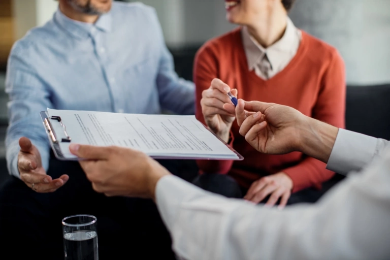 Closeup Unrecognizable Couple Signing Contract With Financial Advisor