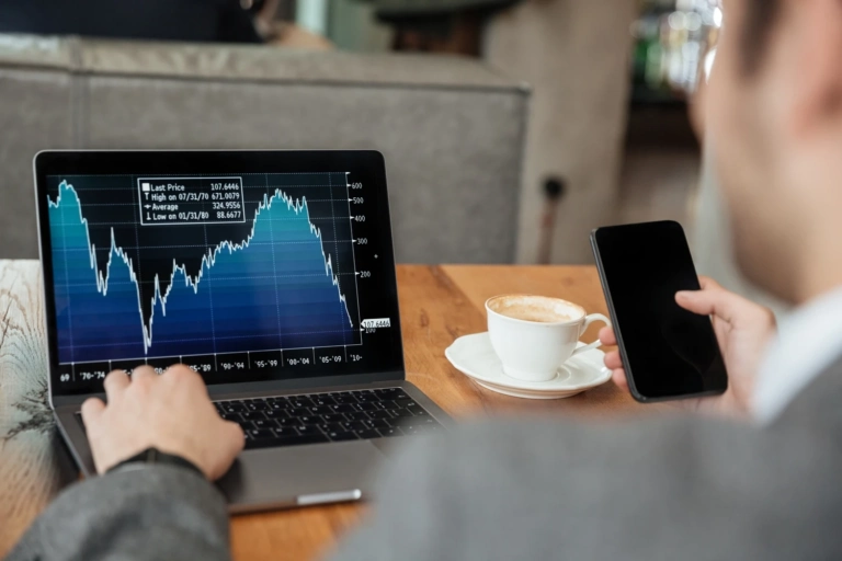 Cropped Image Businessman Sitting By Table Cafe Analyzing Indicators Laptop Computer While Using Smartphone