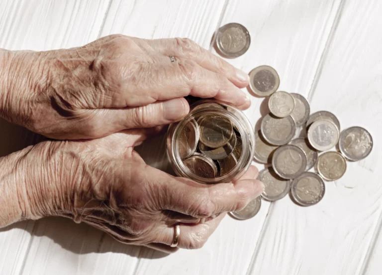 Hands holding jar filled with coins
