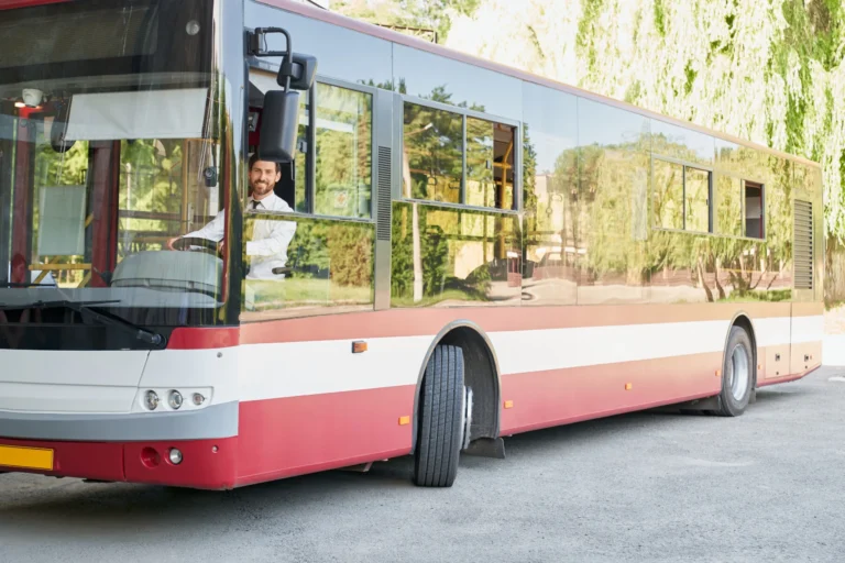 Elegant driver sitting shuttle bus smiling camera summer day front view happy man